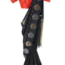 Black saree with gold patterns draped over a red blouse on a white background
